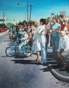 Crowd gathered on sidewalk with bicycle.