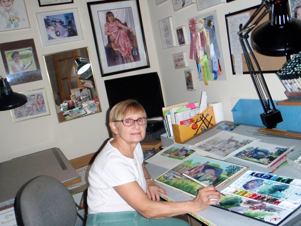 Woman painting watercolors at a desk.